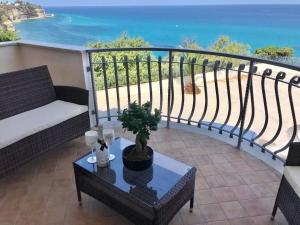 a balcony with a couch and a table and the ocean at Bonsai in Tropea