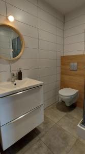 La salle de bains est pourvue d'un lavabo blanc et de toilettes. dans l'établissement Pokoje Gościnne Cztery Wiatry, à Frombork