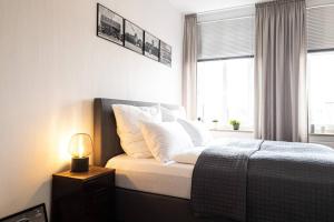 a bedroom with a bed with white pillows and a lamp at Luxus-Apartment in Leipzig mit Privat-Parkplatz in Leipzig