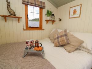 a bedroom with a white bed with a tray on it at Ivy's Way in Rhayader