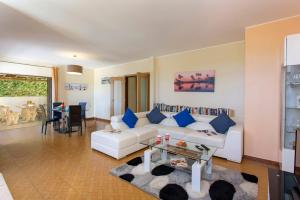 a living room with a white couch and a table at Apartamentos Solar Veiguinha in Albufeira