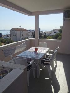 d'une table et de chaises sur un balcon avec vue sur l'océan. dans l'établissement Apartment Toni, à Primošten