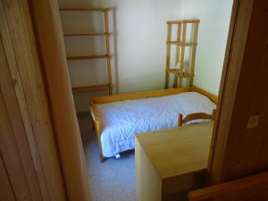 a bedroom with a bed and a dresser at Auberge Le Bois du Cornet in La Forclaz