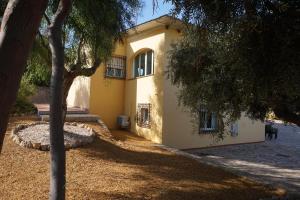 żółty dom z drzewem przed nim w obiekcie Cortijo del Aguila w mieście Mojácar