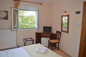 a bedroom with a desk with a computer and a window at Filoxenia Hotel in Volos