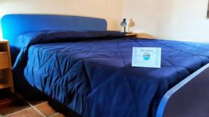 a blue bed with a sign on top of it at VistaMare in Villaputzu