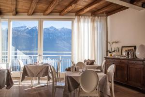 un comedor con mesas y sillas y una gran ventana en Locanda Al Castelletto en Tremosine Sul Garda