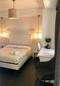 a bedroom with a white bed and a chair at Bonsai in Tropea +80 photos