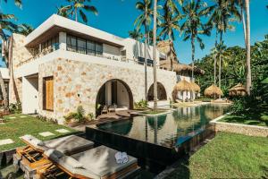 a villa with a swimming pool and palm trees at Alamayah Boutique Retreat Hotel in Deke