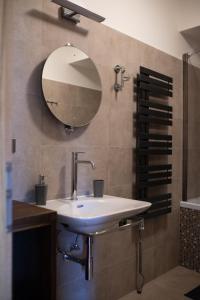 baño con lavabo y espejo en la pared en Apartmány VÍNO HRUŠKA Pardubice, en Pardubice