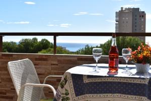 una mesa con dos copas y una botella de vino en Apartamento Playamar en Torremolinos