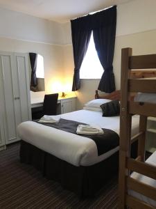 a hotel room with two beds and a bunk bed at The Feathers Hotel in Blackpool