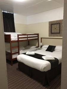 two beds in a hotel room with two bunk beds at The Feathers Hotel in Blackpool