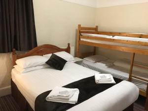 a bedroom with two bunk beds with towels on them at The Feathers Hotel in Blackpool