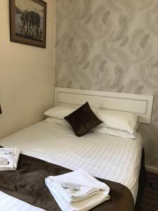 a hotel room with a bed with towels on it at The Feathers Hotel in Blackpool