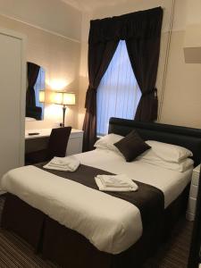 a hotel room with a large bed with a window at The Feathers Hotel in Blackpool +28 photos