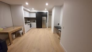 a kitchen with a wooden table and a dining room at Gardenia Apartment an ideal place to relax and enjoy in Clayton North