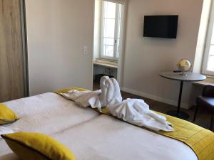 um quarto com uma cama com uma toalha em Domitys - Le Manoir em Pérignat-lès-Sarliève