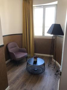 une chambre avec une chaise, une table et une fenêtre dans l'établissement Domitys - Le Manoir, à Pérignat-lès-Sarliève