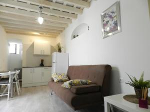 uma sala de estar com um sofá e uma cozinha em Casa Lola, La Plazoleta em Vejer de la Frontera