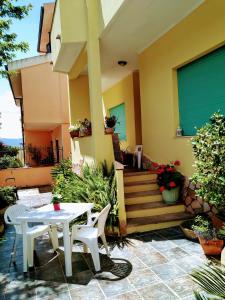 patio ze stołem i krzesłami przed domem w obiekcie B&b Aloysia w mieście Iglesias