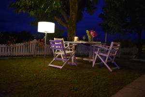 a table with two chairs and a lamp in a yard at Dolomitiloungebelluno Mountain Stay in Belluno