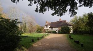 a large white house with a driveway in front of it at FSC Flatford Mill Hostel in East Bergholt