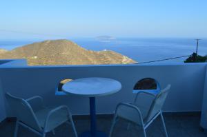 stół i krzesła na balkonie z widokiem na ocean w obiekcie The Anafians Studios w mieście Anafi