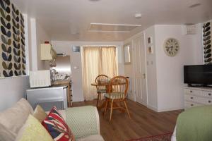 a living room with a couch and a table at Little Flint in Kent