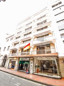 un gran edificio blanco en una calle de la ciudad en Hotel Santa Monica en Cuenca