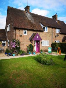 una vieja casa de ladrillo con una puerta morada en Avebury Life, en Avebury