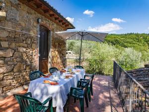 un tavolo su un balcone con ombrellone di Villa Loggiato a Pergine Valdarno