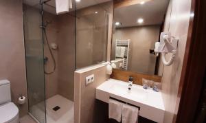 a bathroom with a shower and a sink and a toilet at Hotel Urogallo in Vielha +28 photos
