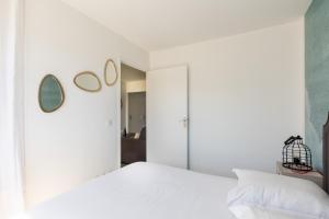 a bedroom with a white bed and mirrors on the wall at DIFY Desaugiers - Jean Macé in Lyon