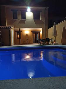 a swimming pool at night with a house in the background at La Casa de Belén in La Torre del Valle