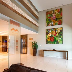 a lobby with a couch and paintings on the wall at Express Vieiralves in Manaus