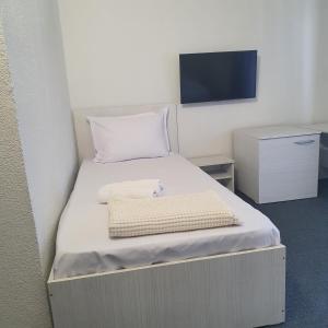 a bedroom with a bed with a tv on the wall at Pensiunea Elmo in Constanţa