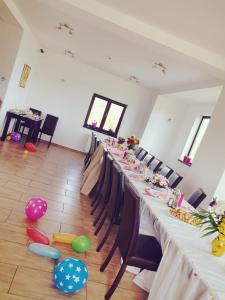a long table in a room with chairs and balloons at Pensiunea Soarelui in Fundata