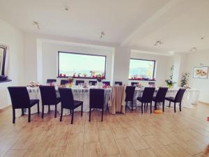 a room with a long table and chairs in it at Pensiunea Soarelui in Fundata