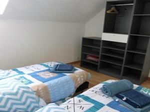 1 dormitorio con 2 camas y estante para libros en Gite es Omnes en Pleurtuit