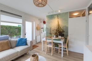 een woonkamer met een bank en een tafel bij Welcome in - Vakantiewoning met zonnige tuin, dichtbij zee en strand I Noordendolfer 2-49 in Zoutelande