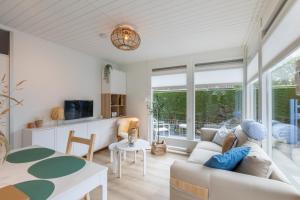 een woonkamer met een bank en een tafel bij Welcome in - Vakantiewoning met zonnige tuin, dichtbij zee en strand I Noordendolfer 2-49 in Zoutelande