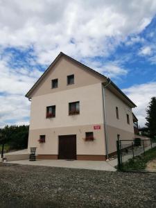 ein großes weißes Gebäude mit Blumen in den Fenstern in der Unterkunft Vinný sklep u Malíků in Drnholec