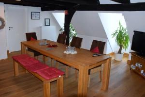 a wooden dining room table with chairs and a television at Haus Buuck - Herberge in Rüthen
