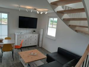 a living room with a couch and a tv and a table at Dat Papenboerger Hus in Zierow