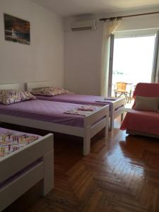 1 dormitorio con 2 camas, silla y ventana en GORAN'S PLACE en Hvar