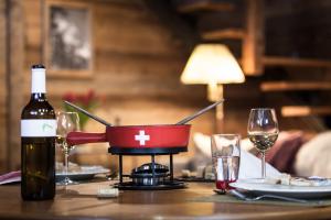 采尔马特Mountain Chalet 4 You的桌子上放一瓶葡萄酒和玻璃杯 更多11张照片