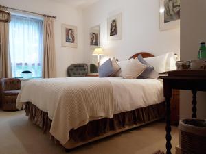 a bedroom with a large bed with white sheets and a window at Chy Bre in Truro