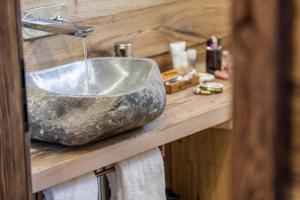 a bathroom with a stone sink with a faucet at Mountain Chalet 4 You in Zermatt