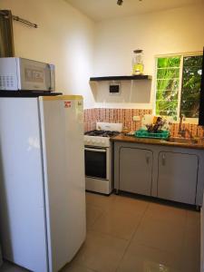 a kitchen with a white refrigerator and a stove at Villa Victoria in Sosúa